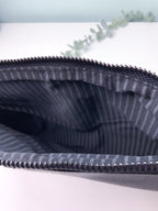 Close-up of a striped fabric pouch with a zipper on a light background