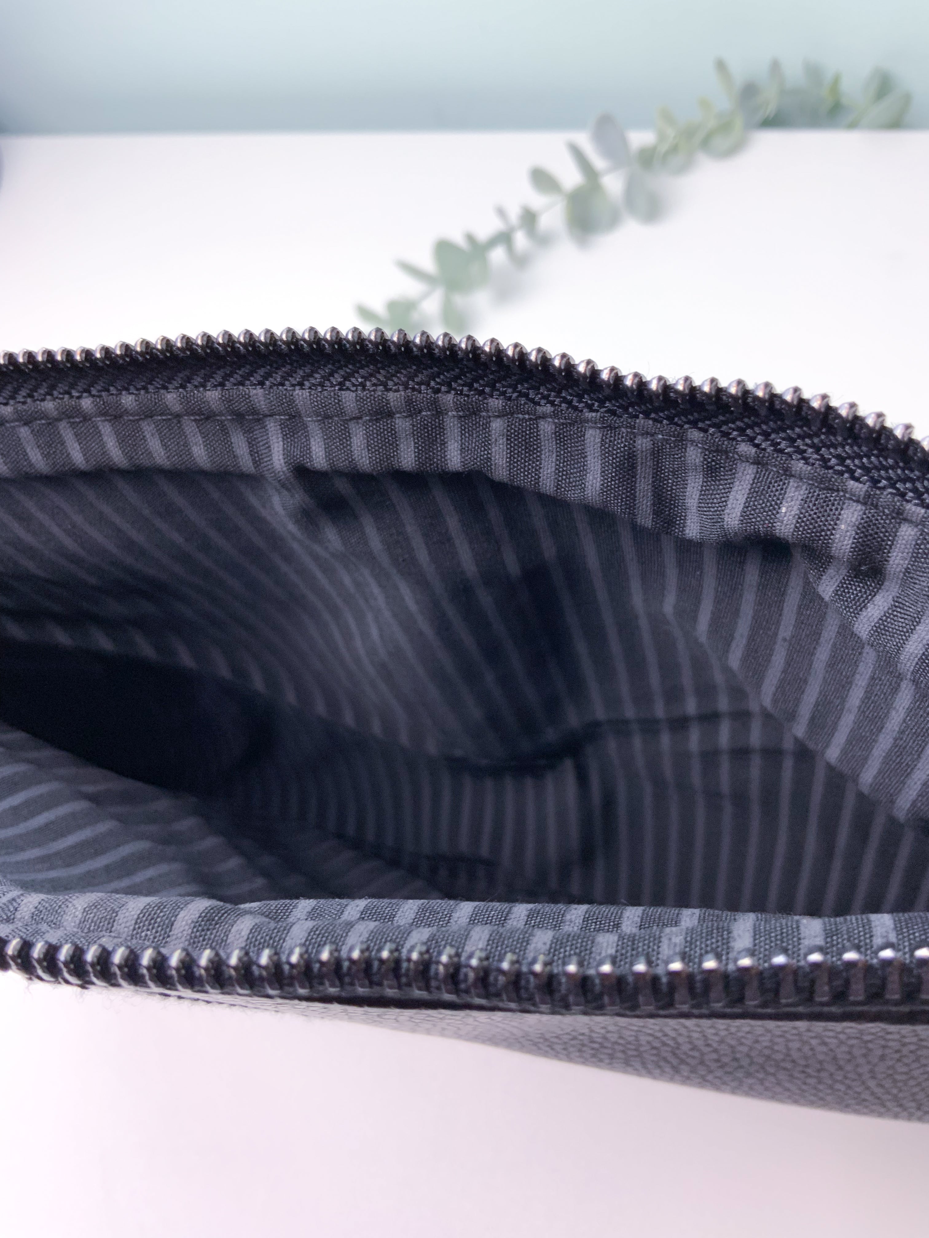 Close-up of a striped fabric pouch with a zipper on a light background